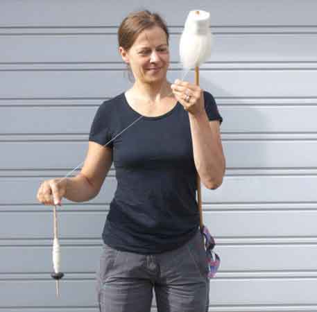 Katrin Kania, a textile archaeologist based in Germany, shows how a spinner makes thread. Here, she pinched a bit from a mass of fibers, attaching it to the spindle in her right hand. A whorl at the spindle’s bottom helps the tool spin and create thread.