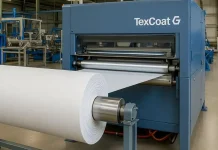 BW Converting to spotlight Baldwin TexCoat® G4 at Guatemala’s 33rd Apparel Sourcing Show TexCoat G4 spray finishing machine in an industrial textile facility with a white fabric roll feeding into it.
