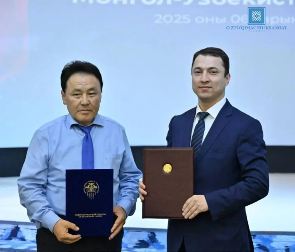 Uzbek and Mongolian textile officials shaking hands at a business forum