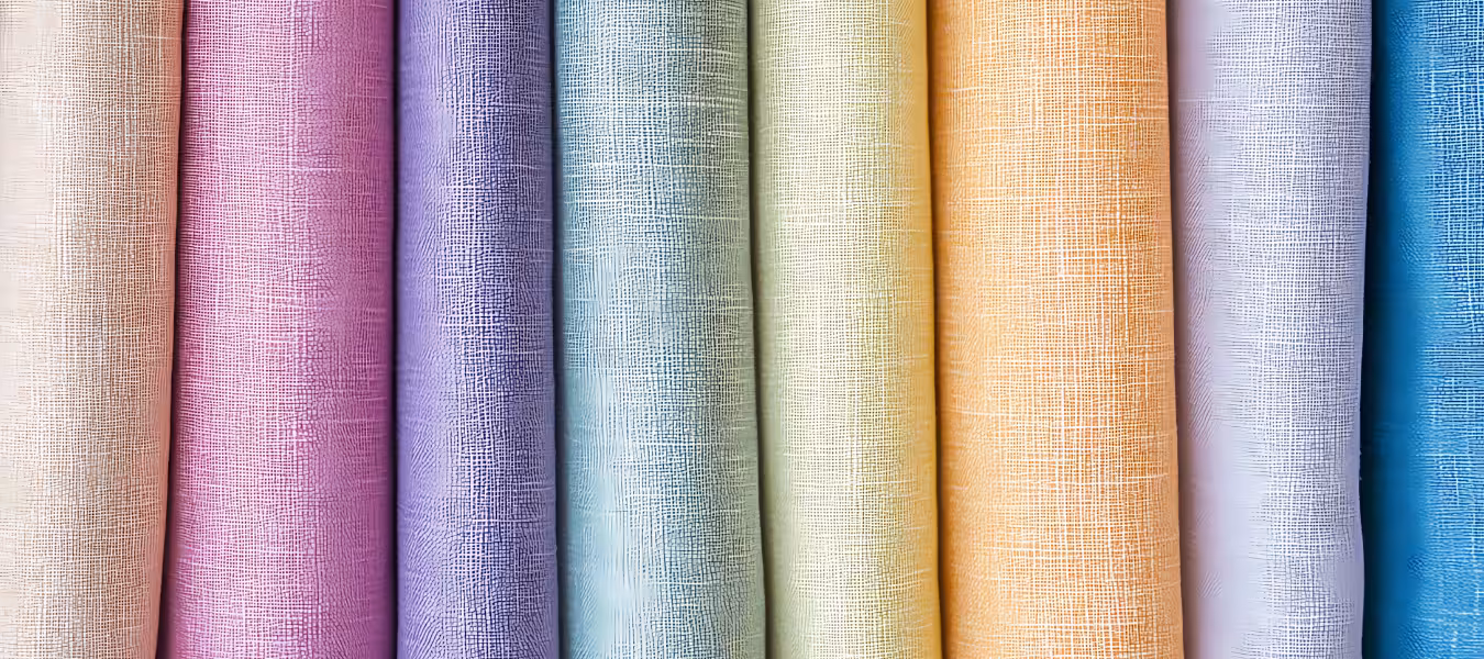Industrial textile factory with multiple colored fabric rolls arranged on large machinery, representing the Future Forward Factories Blueprint theme.