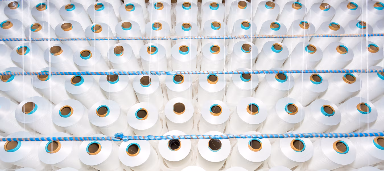 A pattern of white cotton spools with threads. An old system manual loom machine for clothing.
